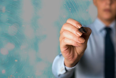 Midsection of man holding mobile phone