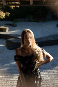 Portrait of young woman while standing outdoors