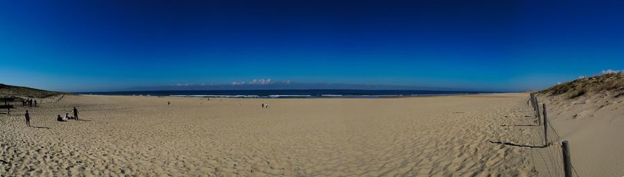 Scenic view of beach against blue sky