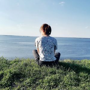 Rear view of woman looking at sea against sky