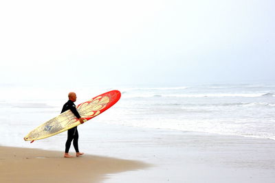 Rear view of woman standing on beach