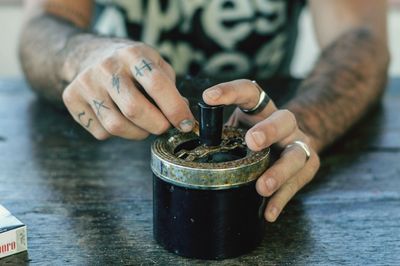 Close-up of hand holding cup on table