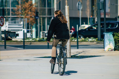 Woman riding bicycle on street in city