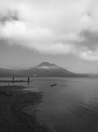 Scenic view of lake by mountain against sky