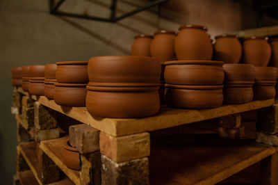 Close-up of clay containers on shelves