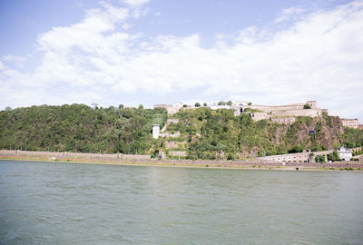 Scenic view of river by trees against sky