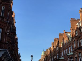 Low angle view of buildings against clear blue sky