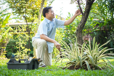 Side view of teenage boy sitting on grass