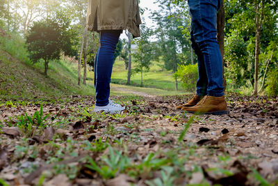 Low section of people walking in forest