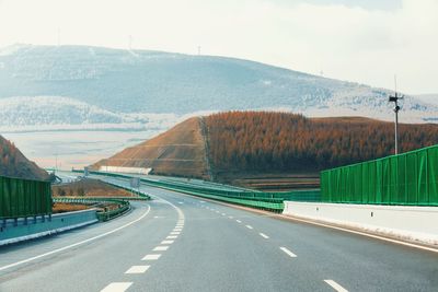 Road by mountains against sky