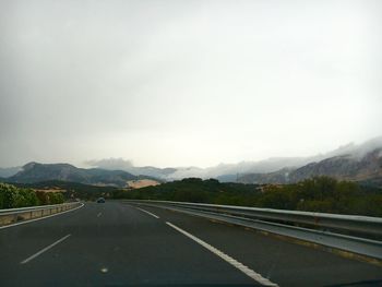 Road passing through mountains against sky