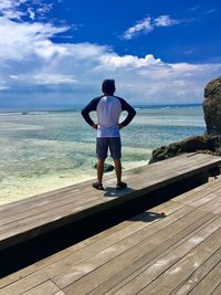 Full length of man standing on sea shore against sky