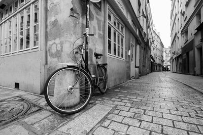 Bicycle parked on footpath by old building