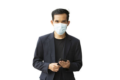 Portrait of young man standing against white background