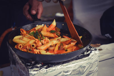 Close-up of person preparing pasta