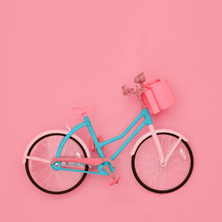 Bicycle with toy against pink background