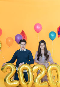 Portrait of a smiling young woman with balloons