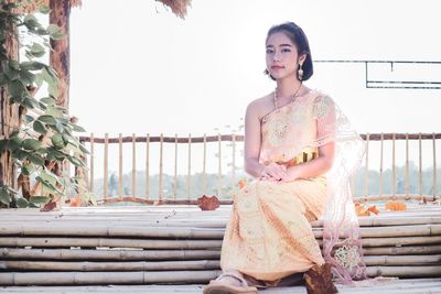 Portrait of girl in traditional clothing sitting at park