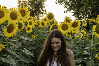 Woman smiling while standing at sunflower farm