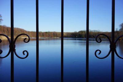 Close-up of metal railing against blue sky