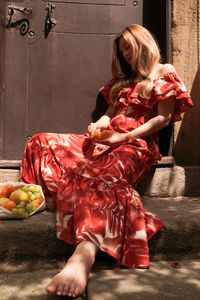 Rear view of woman sitting on table