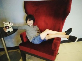 Portrait of smiling girl sitting on chair