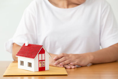 Midsection of man holding umbrella on table in building