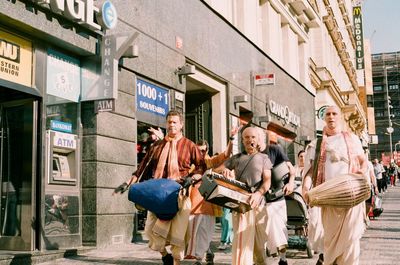 Group of people walking in front of buildings