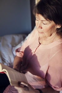 Senior woman reading book in bed