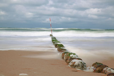 Scenic view of stormy sea against cloudy sky