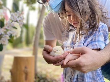 Baby girl holding a chick for the first time