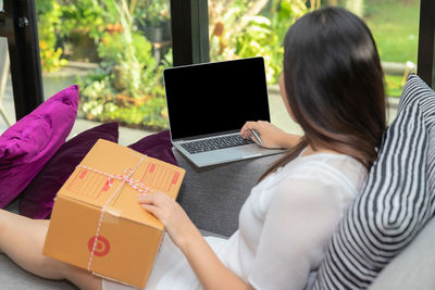 Midsection of woman using digital tablet