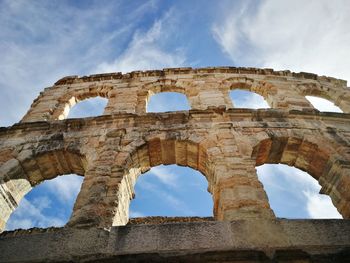 Low angle view of historical building against cloudy sky
