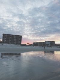 Reflection of buildings in water at sunset