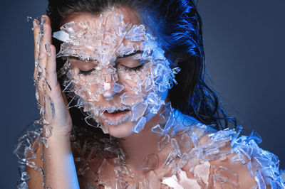 Close-up of woman with face paint against black background