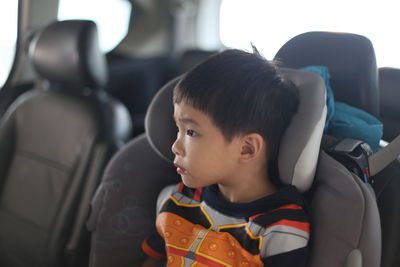 Close-up of boy traveling in car