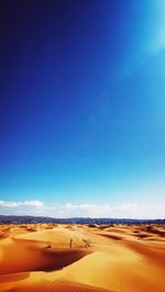 Scenic view of desert against blue sky