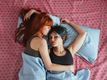 Portrait of lesbian woman with girlfriend lying on bed at home