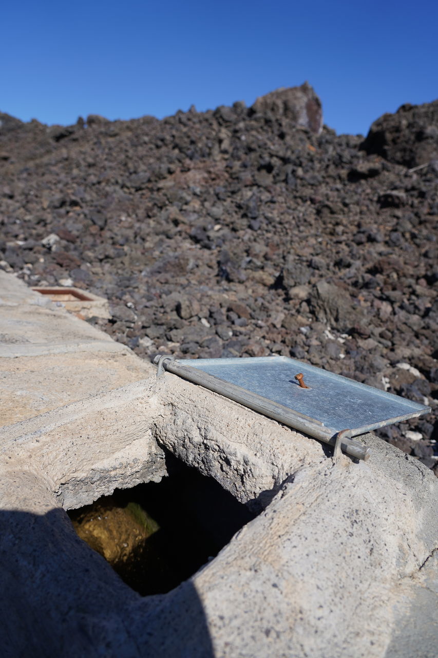 rock, blue, nature, no people, day, outdoors, architecture, sunlight, history, wall, sky, close-up, geology, the past, built structure