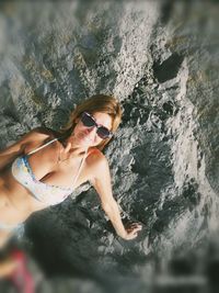 High angle view of woman wearing sunglasses on rock