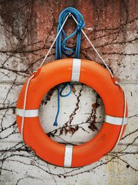 Red umbrella hanging on rope against wall