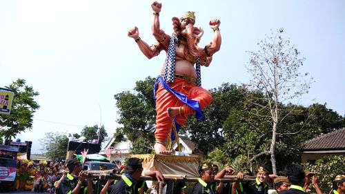 Group of people in traditional clothing against clear sky