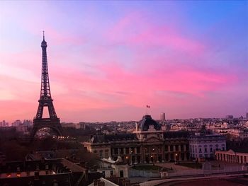 Tower in city against sky during sunset