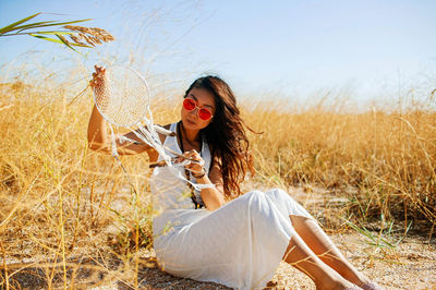 Young woman in field with dry grass