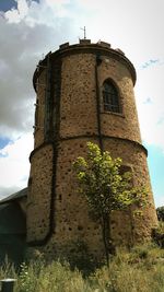 Low angle view of tower against cloudy sky