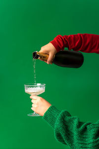 Festive background concept for christmas party, hand pouring champagne, wine into glass