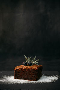 Close-up of cake on table against black background