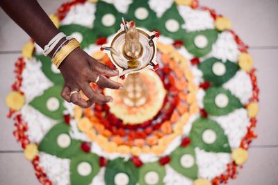 Cropped hand of woman touching diya