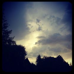 Low angle view of silhouette trees against sky