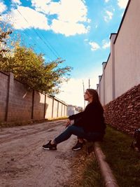 Man sitting by plants against sky